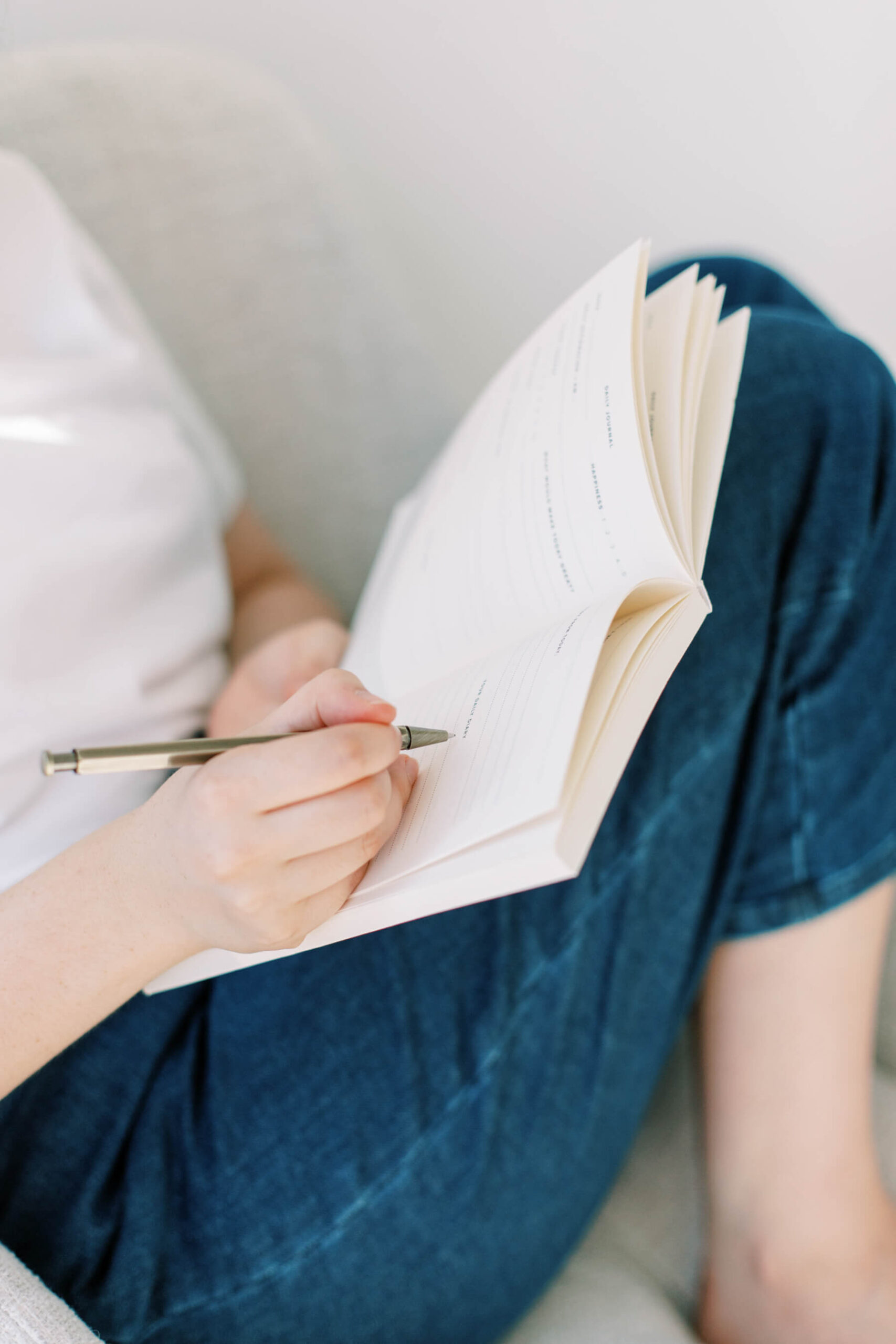 woman writing in a notebook wearing jeans
