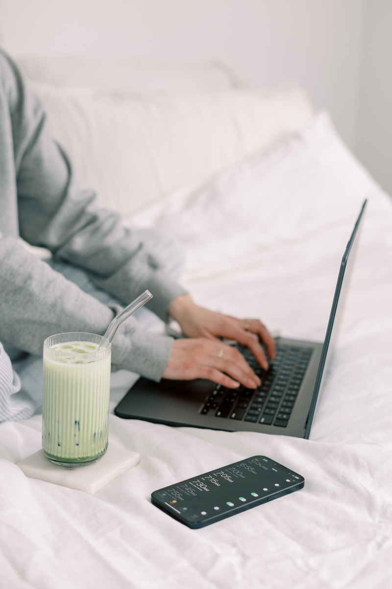 woman working on her website with a matcha latte