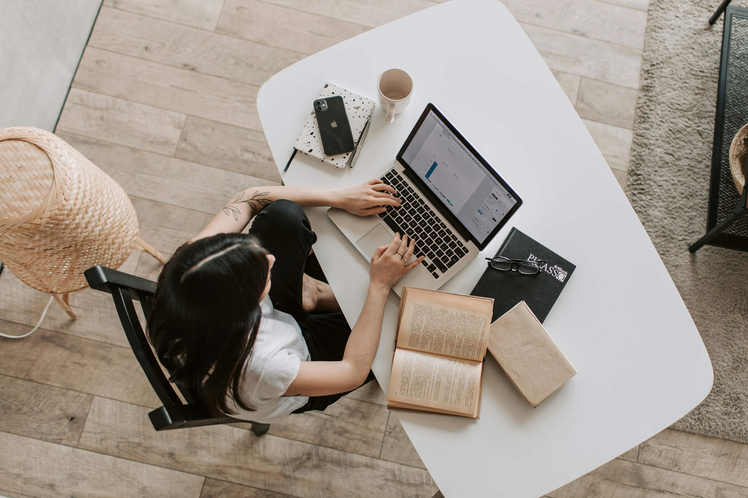 seo coach typing up a blog with books around her on a desk