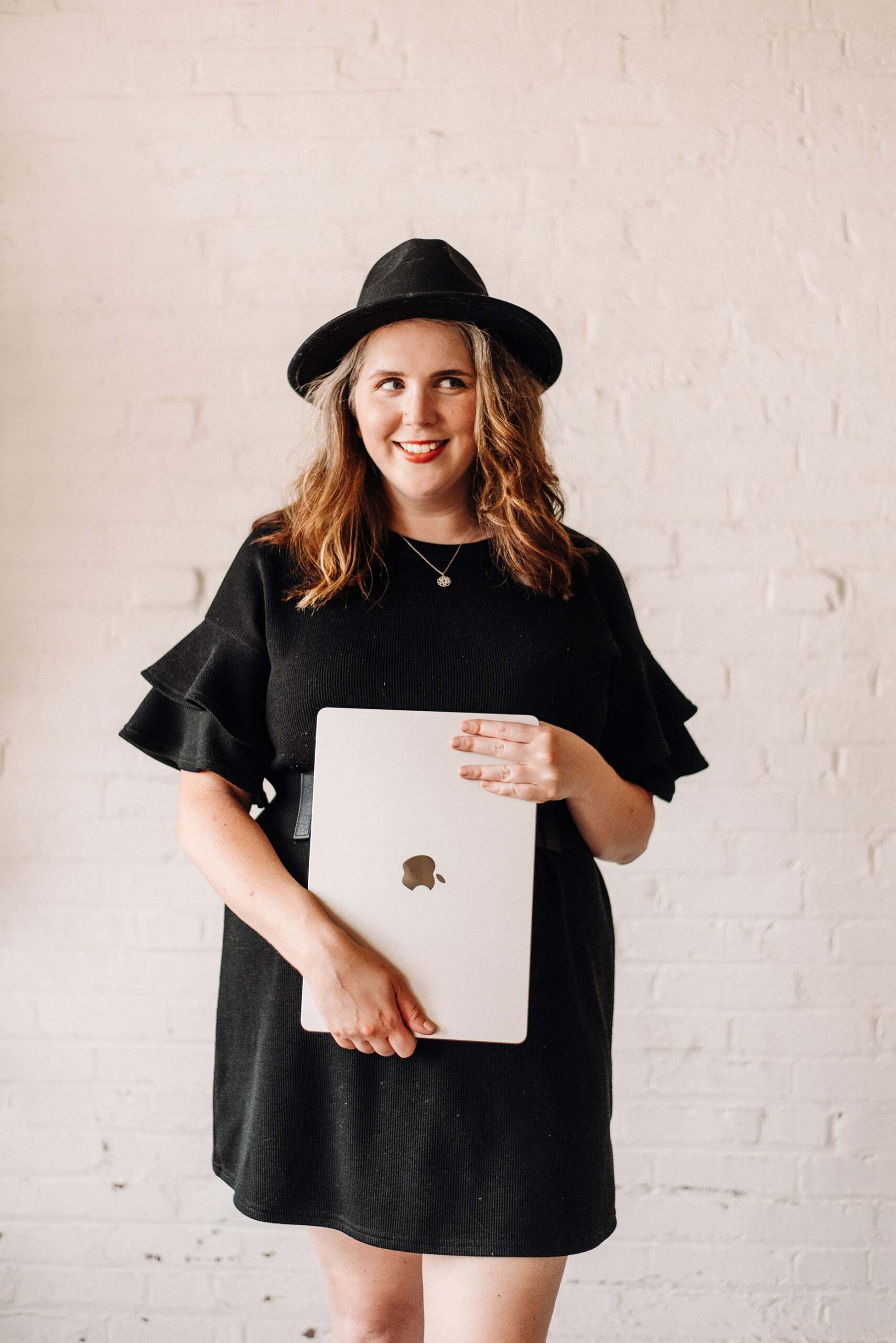 Kristin Pruis, web designer, holding her macbook laptop