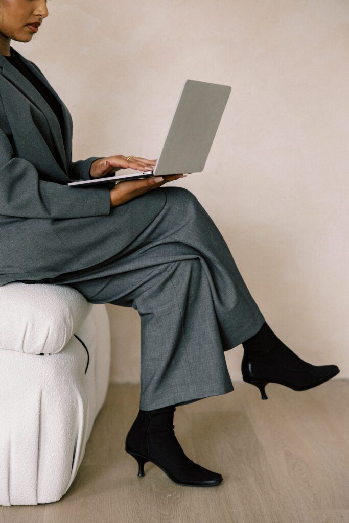 Person sits cross legged while working on their computer